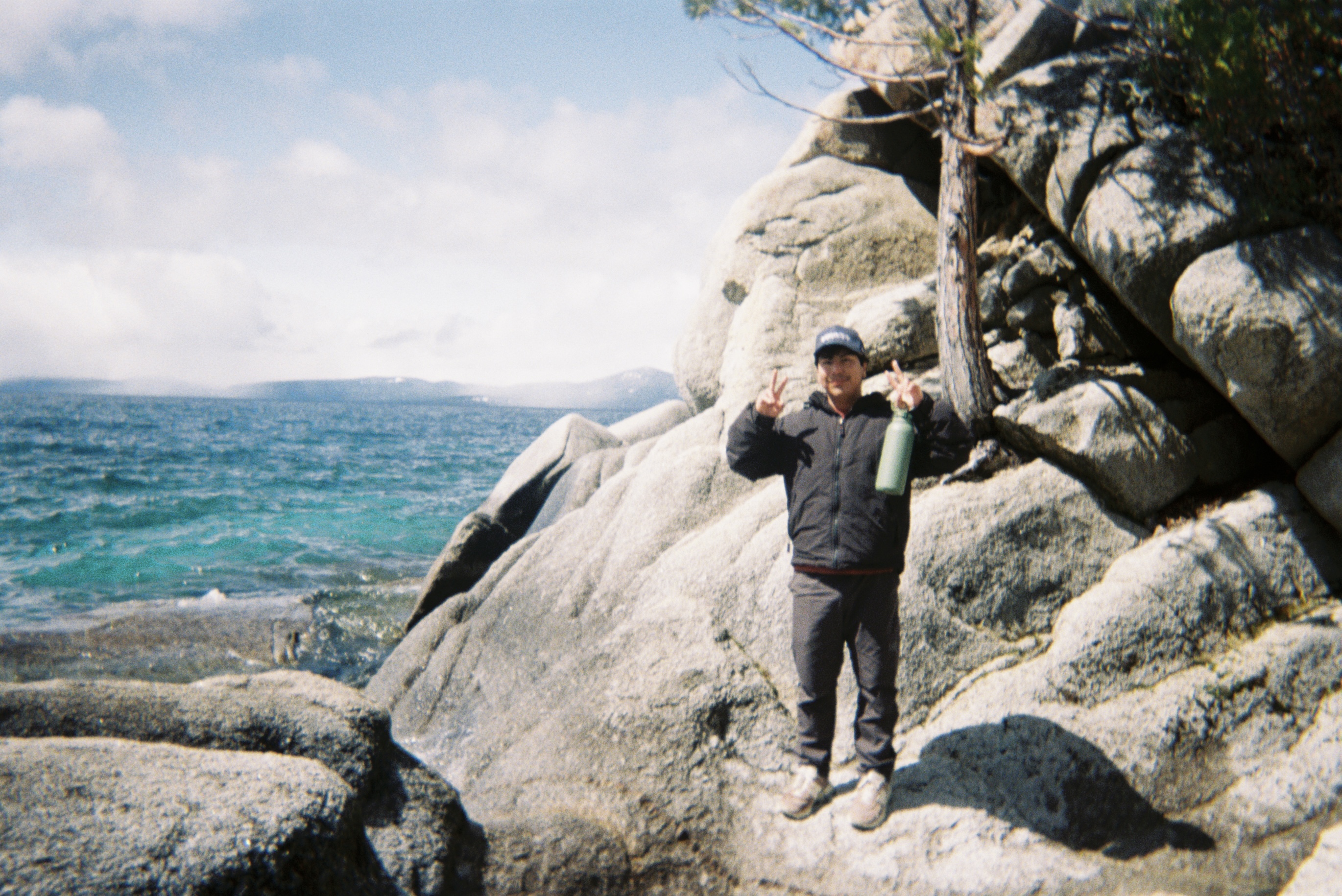 Adrian at a lake with mountains in the background