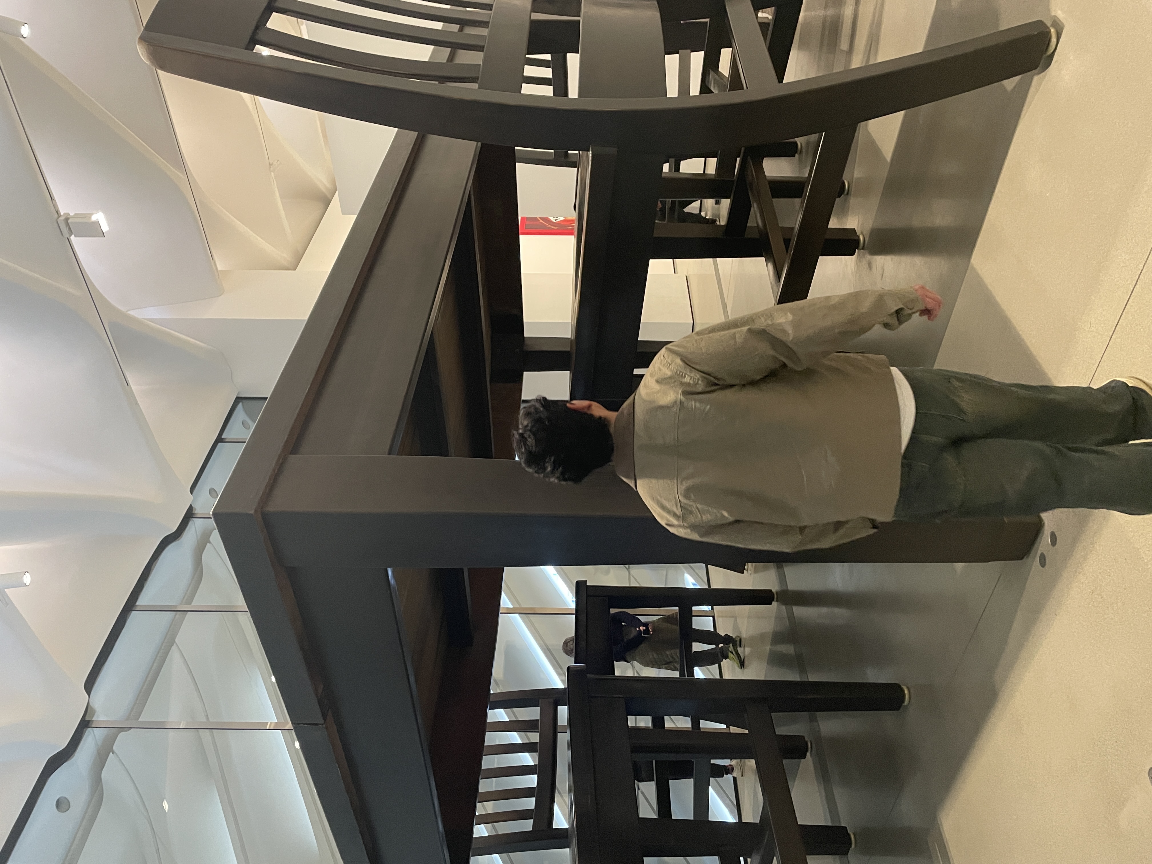 Person viewing oversized furniture art installation in a museum